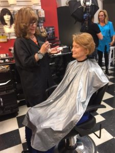 Accessories with a flair...and hair - Greeley's women's clothing boutique and hair salon - A woman sitting in a chair getting her makeup done